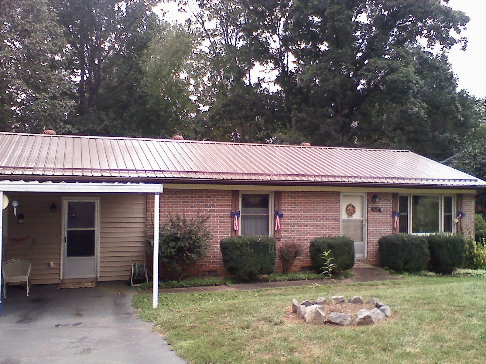 Bronze metal roof and carport on a brick ranch home — Roof Repair work by our crew in Grandview